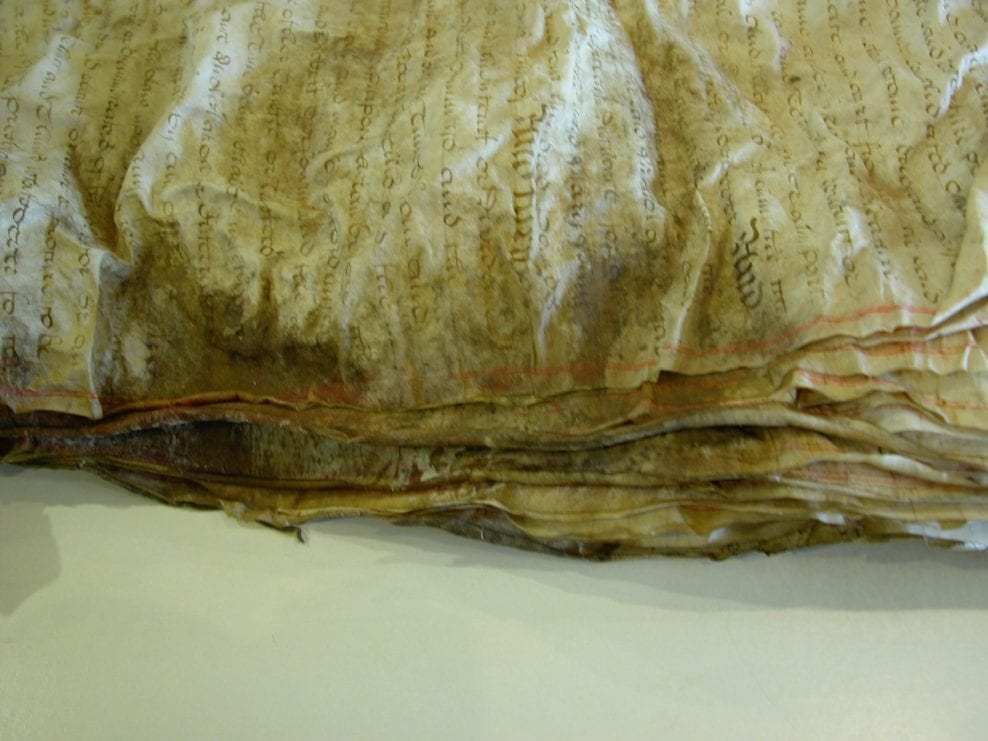 A set of parchment documents, distorted and stuck together