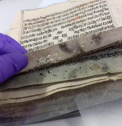 Hindi manuscript with mould, insect damage and adhered pages.